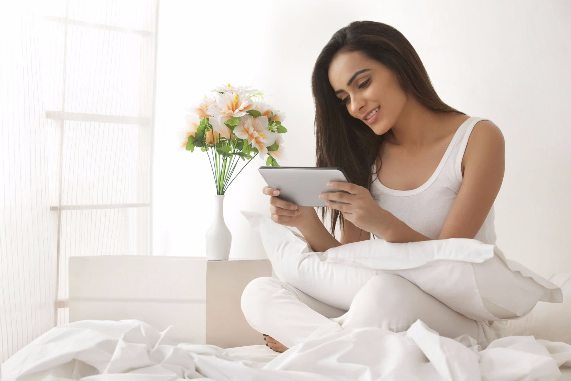 Young woman in clean, calm, clinical surroundings looking at a digital tablet